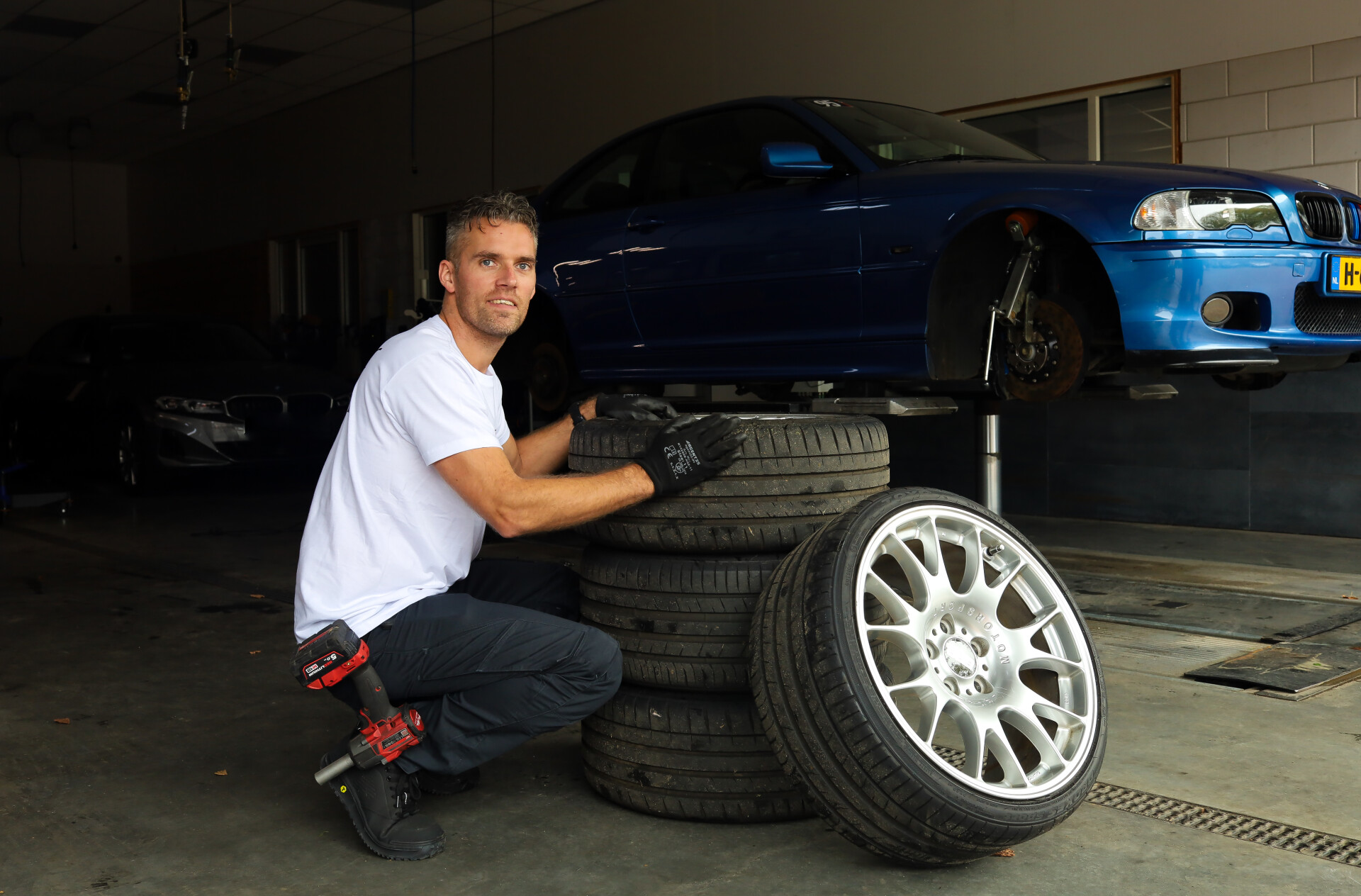 Johannes bij 4 velgen die voor een auto op een brug liggen